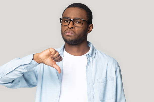 istock Dissatisfied african American man show thumb down unhappy with service 1201144351