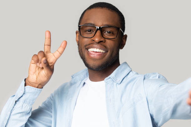 istock Smiling black man in glasses make selfie on gadget 1201144362
