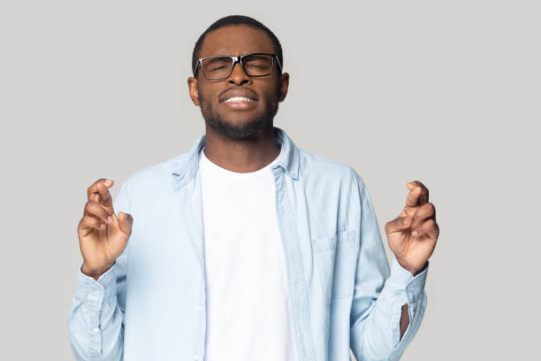 istock Superstitious black male cross fingers making wish 1201144365