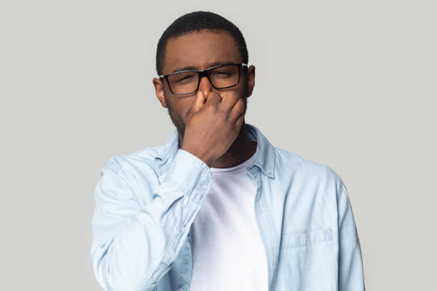 istock Unhappy african American man cover nose avoid bad smell 1201144382