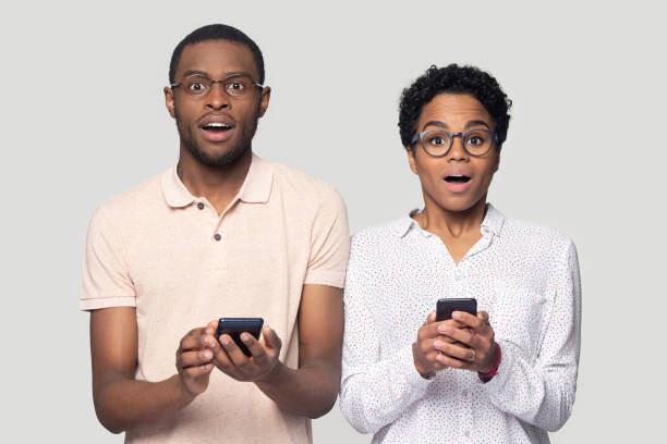 istock Amazed ethnic couple surprised by message on smartphone 1201144423