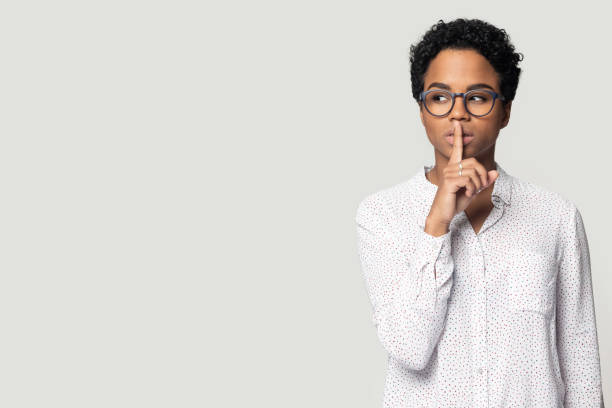 istock Black woman keep finger at lips aside blank copy space 1201144443