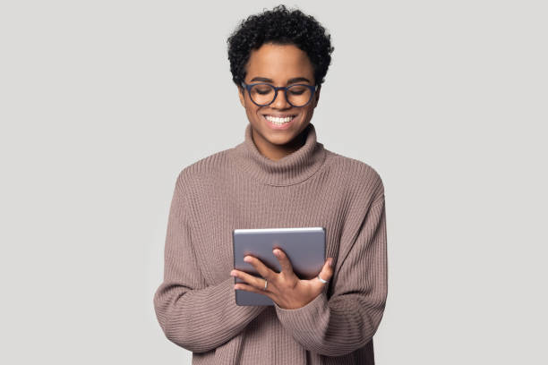 istock Smiling african American girl using tablet browsing internet 1201144502