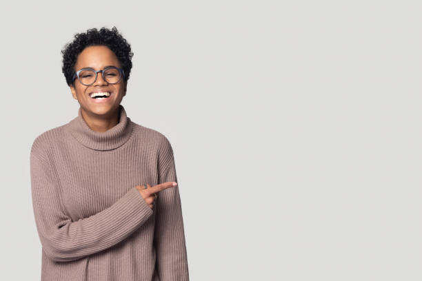 istock Smiling black girl in glasses point at copy space 1201144504