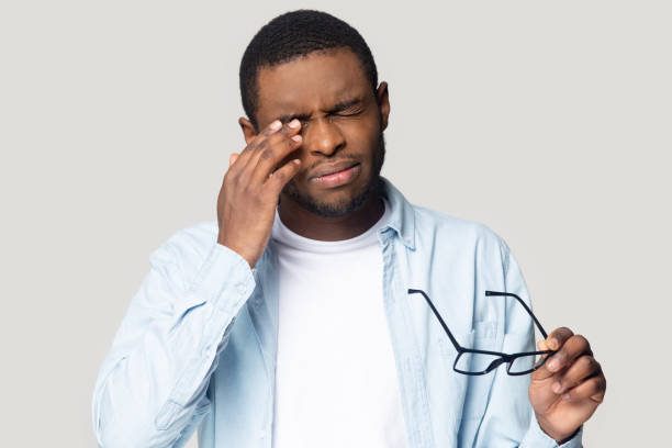 hombre afroamericano se quita los anteojos que sufren de dolor de cabeza - eyes contact fotografías e imágenes de stock