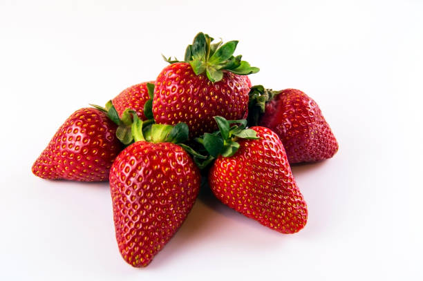 Several pieces of a big red strawberry on a white background