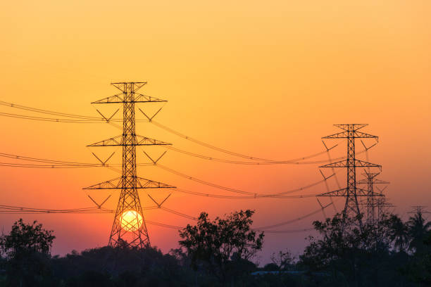 Sunset with high tension electric poles on the middle of paddy fields in the evening. Sunset with high tension electric poles on the middle of paddy fields in the evening. high energy physics stock pictures, royalty-free photos & images