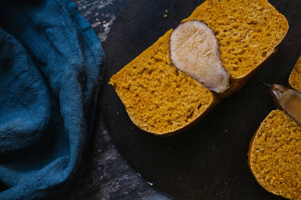 istock Yellow bread with a baked pear inside. Blue background  atmospheric still life 1201150189