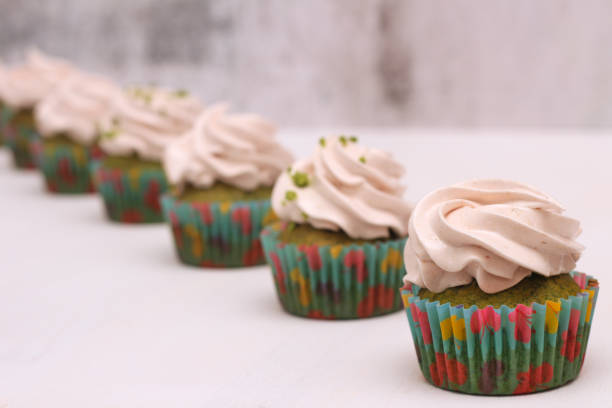 istock A row of spinach-mint cupcakes with fruit jam and berry cream on top 1201150685