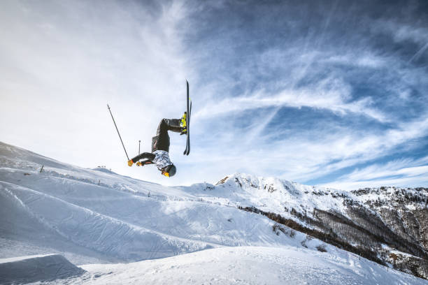 Skier doing a backflip jump in Alps ski resort, Alpe di Mera, Piedmont, Italy Skier doing a backflip jump in Alps ski resort, Alpe di Mera, Piedmont, Italy acrobatic activity stock pictures, royalty-free photos & images