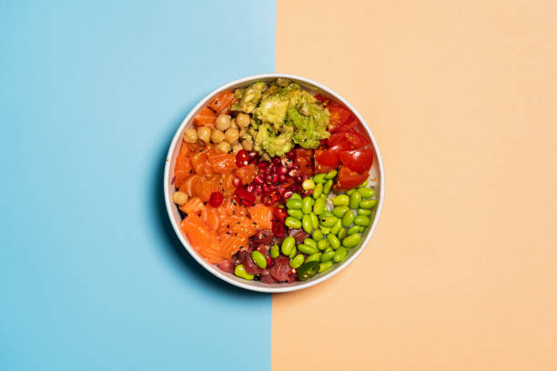 hawaiian poke bowl with rice, salmon, avocado, tomatoes, tuna, chickpeas, pomegranate and edamame. top view from above. - divided plate imagens e fotografias de stock