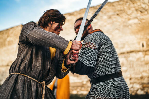 istock Two ancient warriors in armor with weapons fighting with swords 1201157506