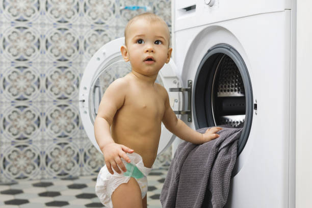 istock Cute baby boy beside the washing machine 1201158402