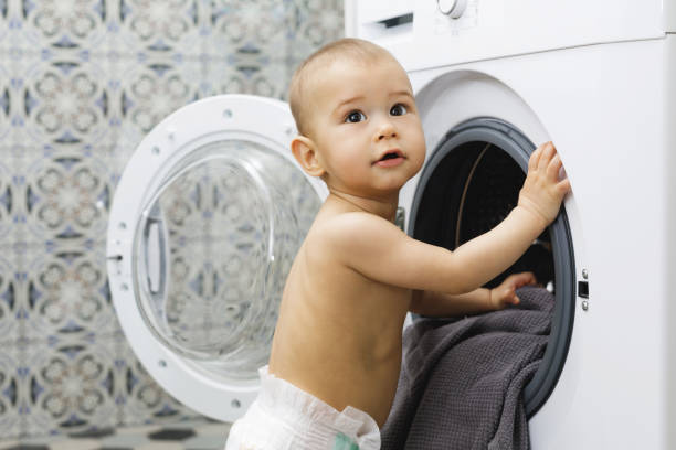 istock Cute baby boy beside the washing machine 1201159029