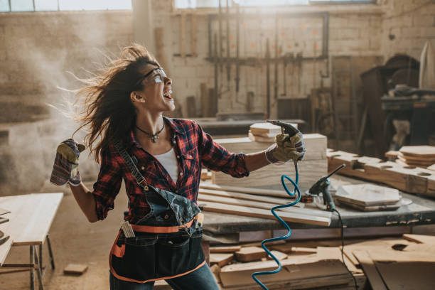 istock Playful female worker having fun with air gun in a workshop. 1201160438