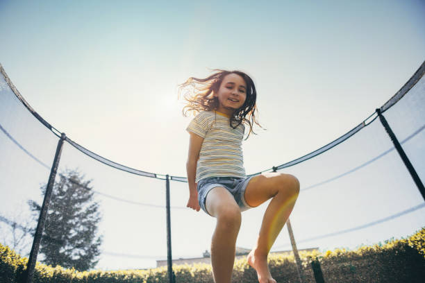 istock little girl jumping on trampoline 1201161046