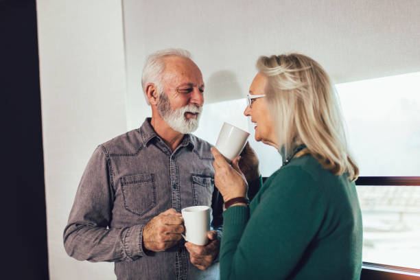 istock Senior couple holding white mugs at home 1201161895