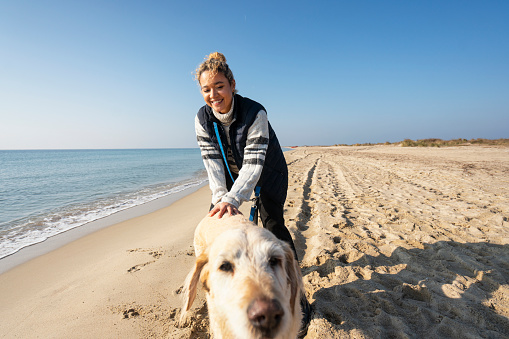 Young Woman spending time with her dog on the beach