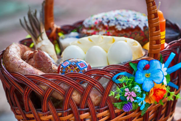 elegante cesta de pascua con comida. rábano picante, mantequilla, salchichay huevos pintados en cesta de mimbre. - consecrated fotografías e imágenes de stock