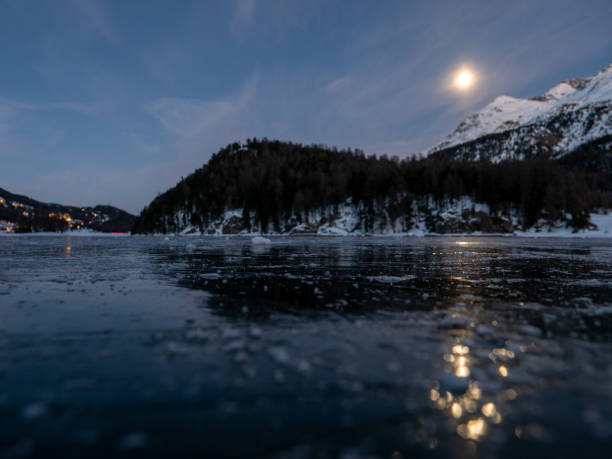 frozen lake and snowcapped mountain in switzerland - light effect full moon mountain peak european alps imagens e fotografias de stock