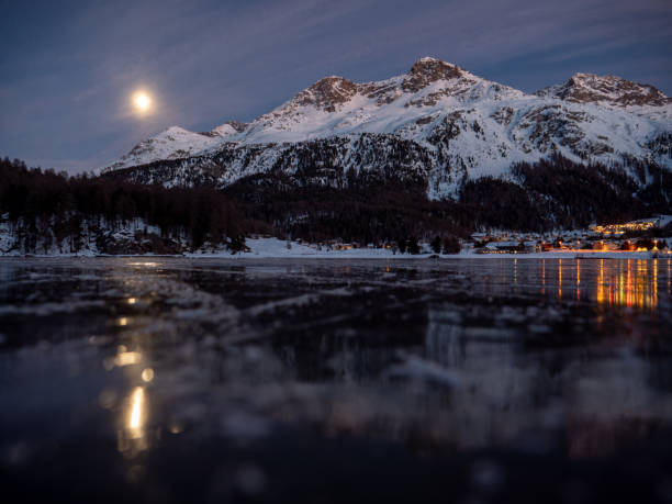 frozen lake and snowcapped mountain in switzerland - light effect full moon mountain peak european alps imagens e fotografias de stock