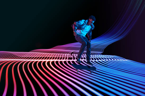 istock Caucasian young skateboarder riding on dark neon lighted line background 1201170446