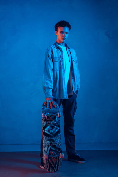 istock Caucasian young skateboarder posing on dark neon lighted background 1201170543