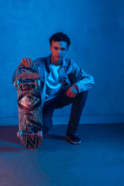 istock Caucasian young skateboarder posing on dark neon lighted background 1201170549