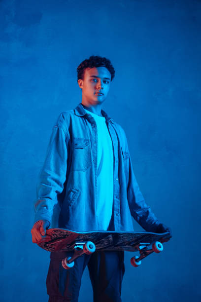 istock Caucasian young skateboarder posing on dark neon lighted background 1201170576