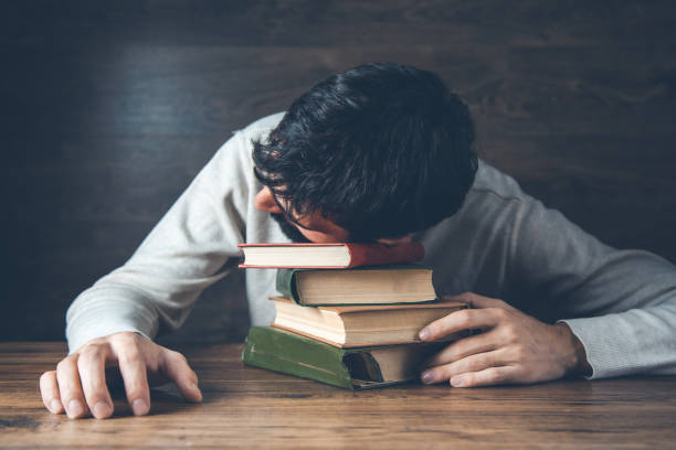 istock sad man head on book on desk 1201172817