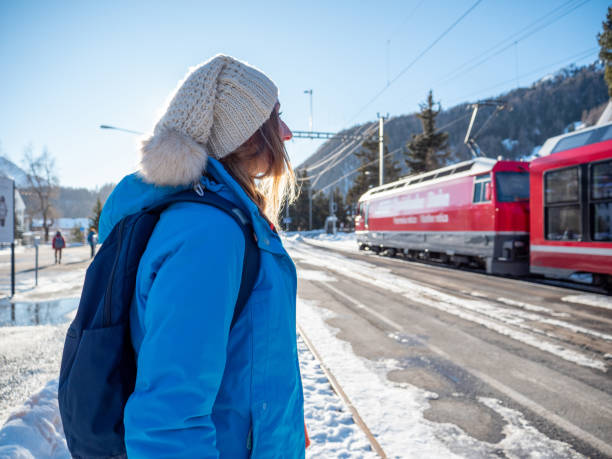 역에서 그녀의 기차를 기다리는 젊은 여자 - graubunden canton switzerland station mountain 뉴스 사진 이미지