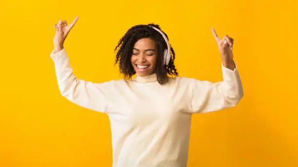 Photo of Smiling afro woman listening to music and dancing