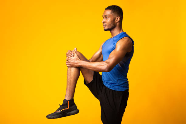 istock Young black sportsman walks highly holding knee 1201177351