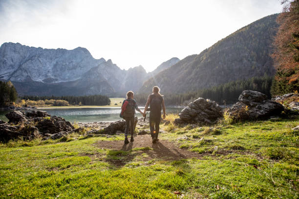 casal adulto de mãos dadas e caminhadas por um lago de montanha - stock photo - kettle - fotografias e filmes do acervo