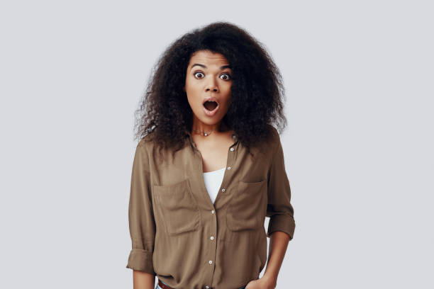 istock Shocked young African woman looking at the camera and keeping mouth open while standing against grey background 1201180103