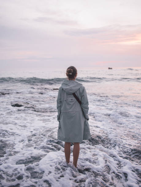 Young woman standing in water at beach stock photo