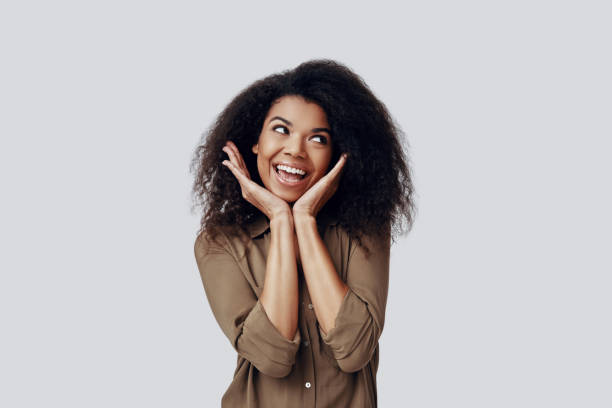 istock Beautiful young African woman smiling and looking away while standing against grey background 1201181815