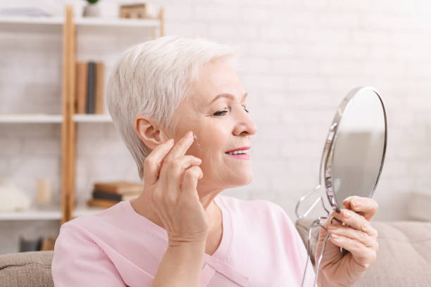 istock Senior lady applying anti aging cream around wrinkles 1201184207