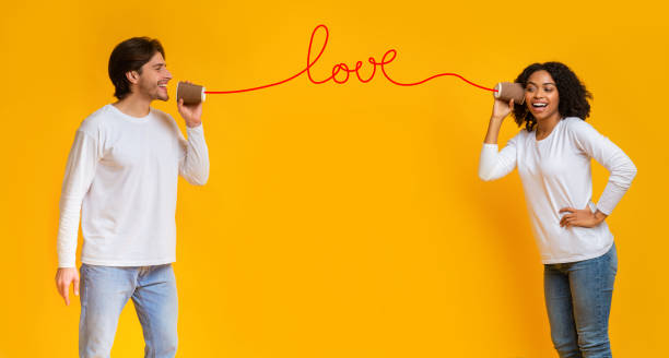istock Love message. Romantic interracial couple talking through tin phone 1201184238