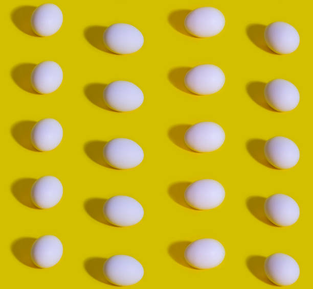 istock Seamless Pattern of white eggs on a pastel yellow background. Easter template 1201185740