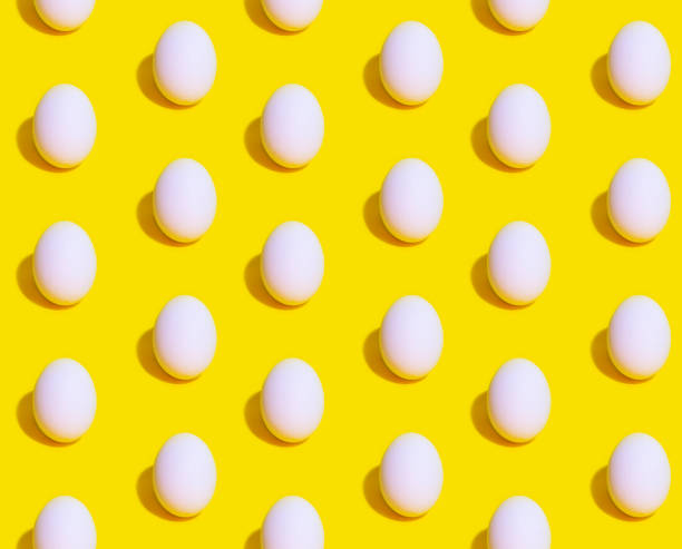 istock Seamless Pattern of white eggs on a pastel yellow background. Easter template 1201185765