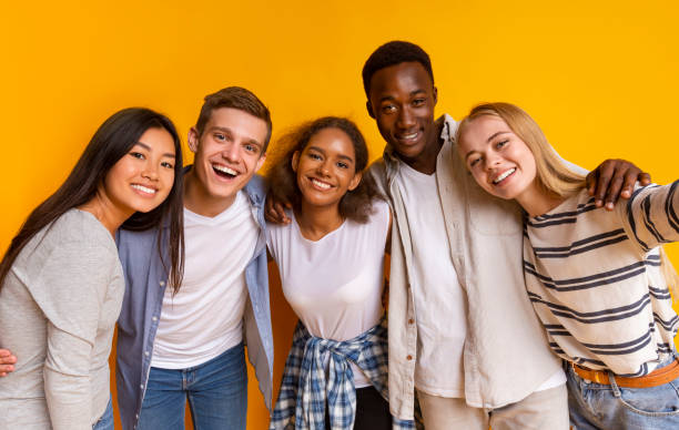 istock Friendly international students taking selfie over yellow background 1201187045