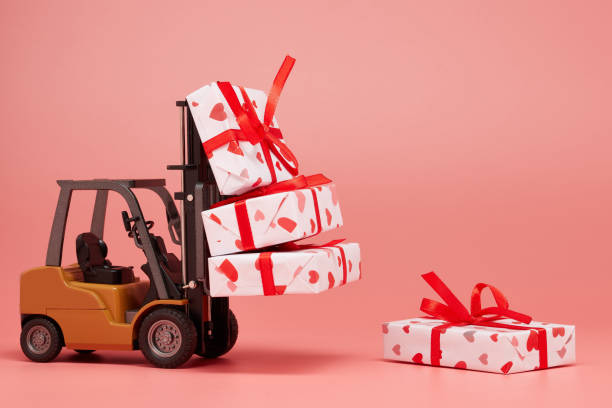 istock Forklift and gift boxes on pink background with copy space. Valentine's Day. 1201187048