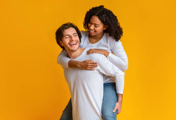 istock Loving Guy Carrying His Afro Girlfriend On Back, Having Fun Together 1201187252