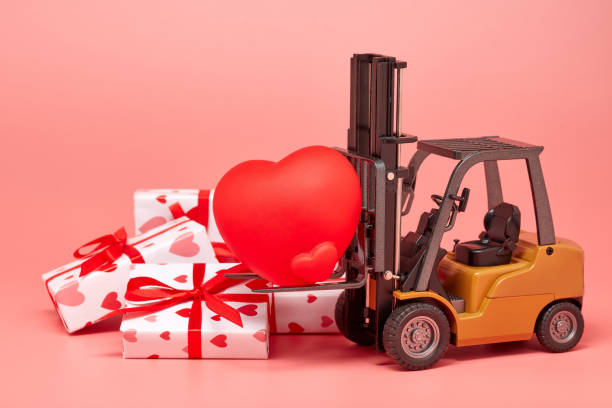 istock Forklift, red heart and gift boxes on pink background. Valentine's Day. 1201187276
