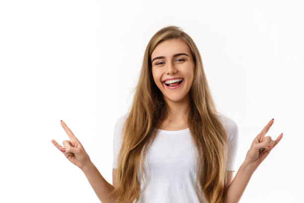 istock smiling young woman showing rock and roll hand 1201187745