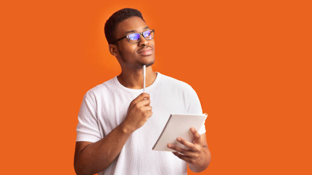 pensive afro man portrait on orange background - made man object imagens e fotografias de stock