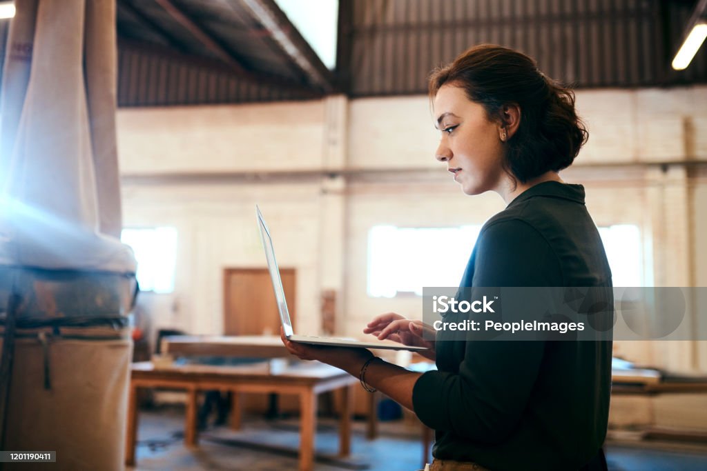 I'm ready to build my client's design Shot of a female carpenter using a laptop in her workshop Wood - Material Stock Photo