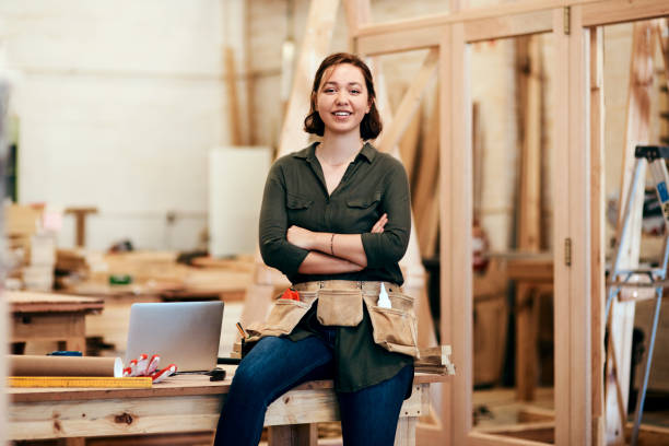 There's nothing you can't do Cropped shot of a young female carpenter smiling at the camera woman wearing tool belt stock pictures, royalty-free photos & images