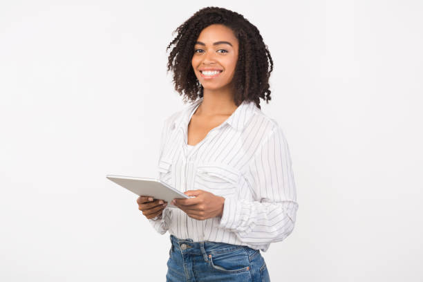 istock Smiling black girl standing with tablet at studio 1201190599